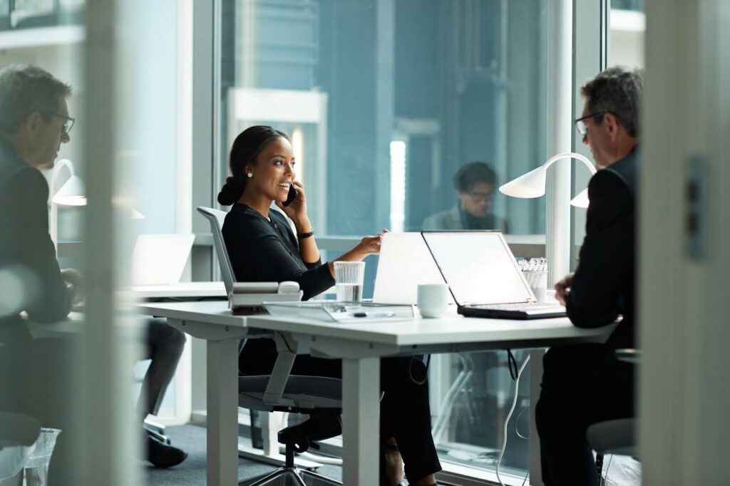 Businesswoman talking on a smartphone in a modern office.